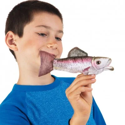 Bambino che gioca con una mini marionetta da dito a forma di trota iridea