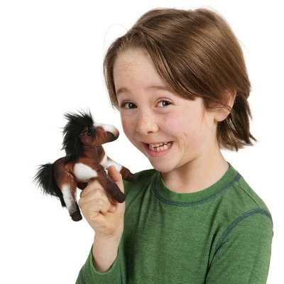 Garçon jouant avec marionnette à doigt mini cheval signée Folkmanis