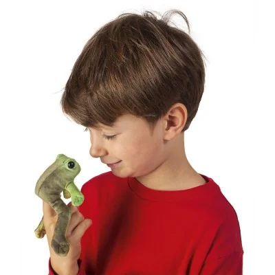 Menino a brincar com um peluche de marioneta de dedo «Mini sapo sentado», da marca Folkmanis Menino a brincar com um peluche de marioneta de dedo «Mini sapo sentado», da marca Folkmanis