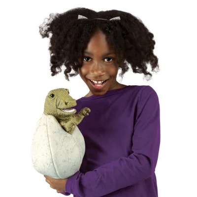 A young girl playing with a Folkmanis baby dinosaur hand puppet in its egg A young girl playing with a Folkmanis baby dinosaur hand puppet in its egg