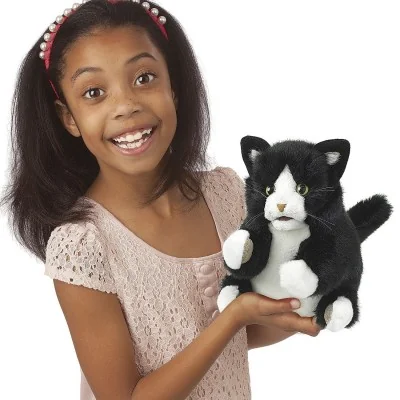 Jeune fille jouant avec marionnette à main chaton noir et blanc signée Folkmanis