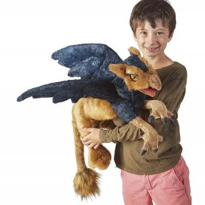 A young man playing with a Folkmanis griffin hand puppet