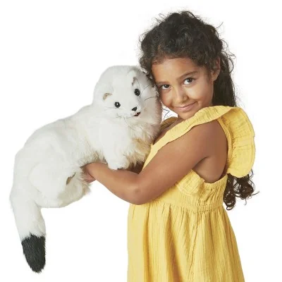 A young girl playing with a Folkmanis-branded ermine hand puppet
