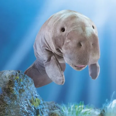 Burattino a mano a forma di lamantino firmato Folkmanis in un ambiente acquatico. Burattino a mano a forma di lamantino firmato Folkmanis in un ambiente acquatico.
