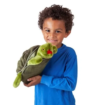 Niño jugando con una marioneta de mano con forma de tortuga de la marca Folkmanis