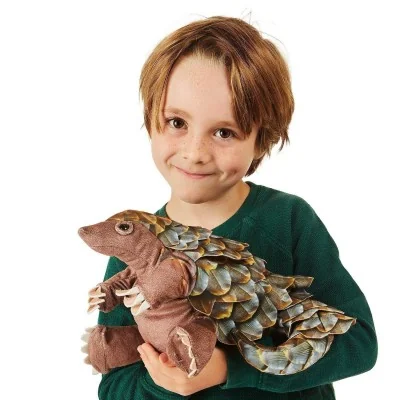Boy playing with a Folkmanis pangolin hand puppet