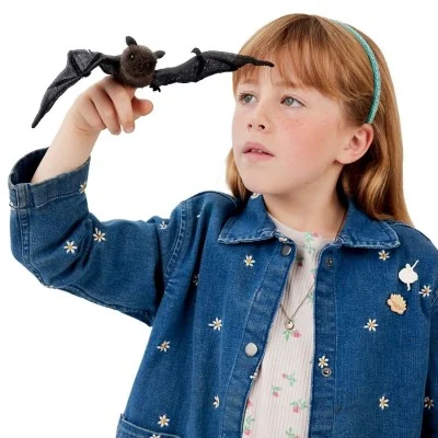 Niña jugando con una mini marioneta de murciélago de la marca Folkmanis
