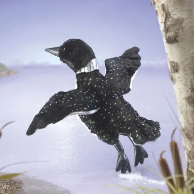 Marionnette à main Plongeon huard signée Folkmanis dans un décor de lac