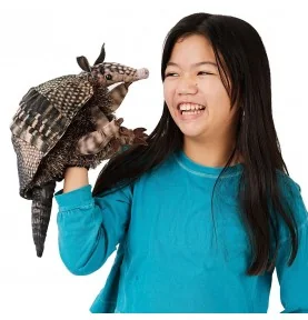 A young girl playing with a Folkmanis-branded armadillo puppet
