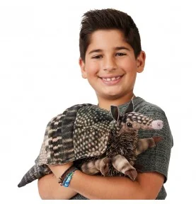 A young man playing with a Folkmanis-branded armadillo plush puppet