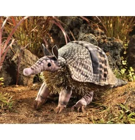 Folkmanis armchair puppet of an armadillo, set against a wild backdrop