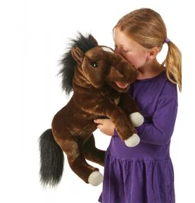 Mädchen, das mit einer von Folkmanis signierten Handpuppe in Form eines Pferdes spielt