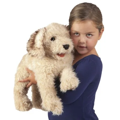 Niña con una marioneta de mano de un labradoodle en brazos