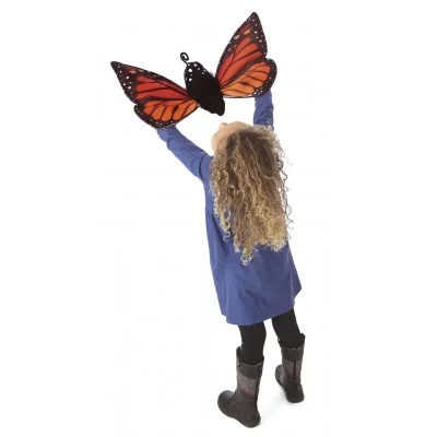 Menina a brincar com uma marioneta de mão Metamorfose da borboleta monarca