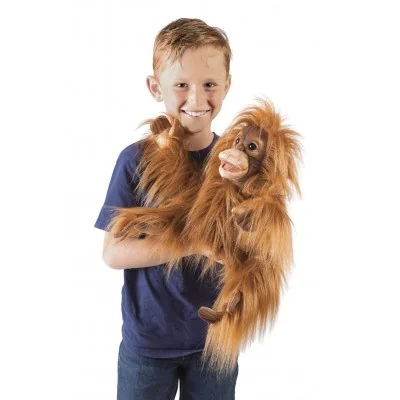 Menino com uma marioneta de mão representando um bebé orangotango nos braços